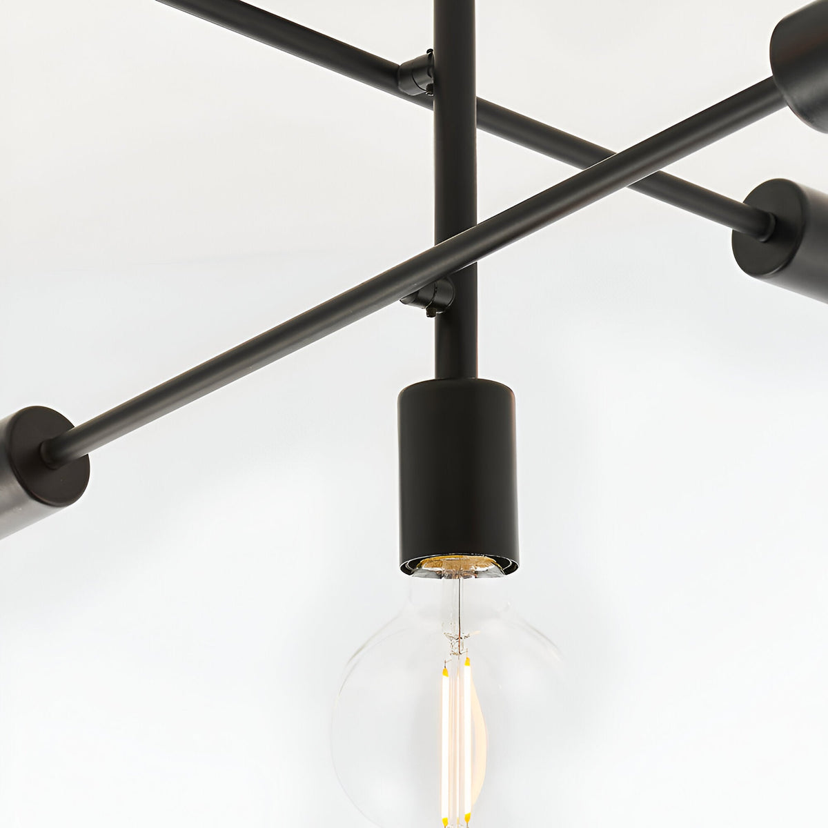 Close-up of Endon Marlowe 5 Light Semi-Flush Ceiling Light in black, showing a matte metal arm, cylindrical lamp holder, and exposed E27 filament bulb.