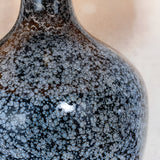 Close-up of the Endon Brenwick table lamp showing its black glass body with grey speckled detailing and matt nickel neck fitting.
