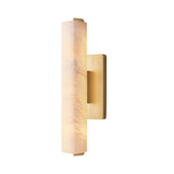 The Selvara LED Small Alabaster Wall Light features a vertical cylindrical alabaster shade and a brushed brass base, shown here in soft white against a white background.