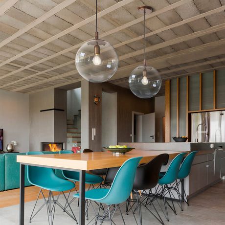 Global Globe Pendant Light - 60cm clear acrylic sphere shade with bronze metal suspension, shown above a wooden dining table in a modern kitchen setting.