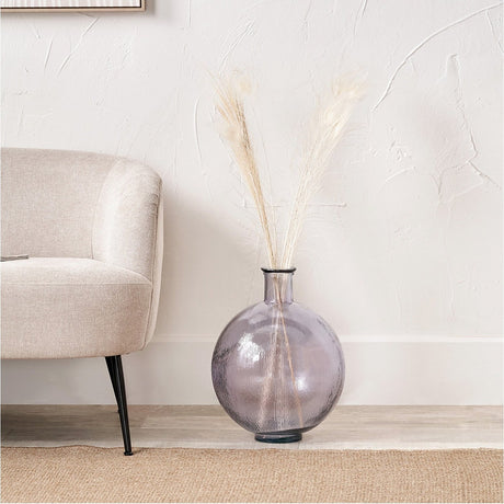 Lilac Recycled Glass Vase, 34cm, round bulbous shape with narrow neck, styled with dried pampas grass beside a beige armchair in a living room.