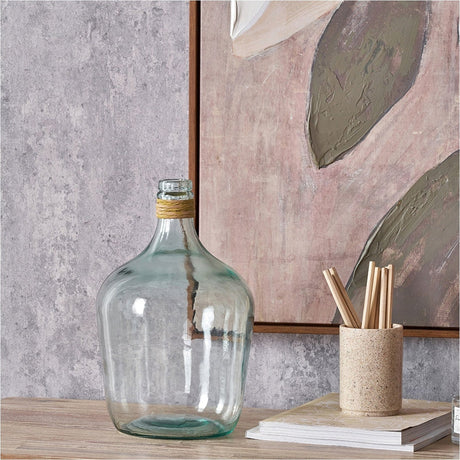 Clear recycled glass bottle vase, 30cm, with a raffia-wrapped neck, shown on a wooden shelf beside a pencil pot and framed artwork.