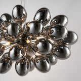 Endon Brenworth 8 light pendant with cluster of electro-plated dark chrome glass globe shades on a black chrome sputnik frame, shown against a pale background.