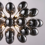 Endon Brenworth 8 light pendant in black chrome with cluster of electro-plated dark chrome glass shades and warm G9 lamps, shown against a pale background.