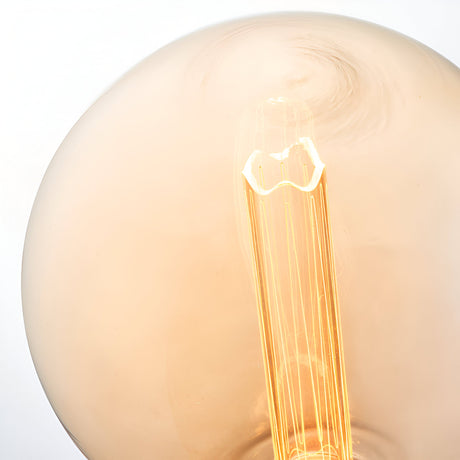 Close-up of Endon 2.8W E27 LED globe bulb showing amber tinted glass and etched acrylic sleeve glowing warm white at 1800K.