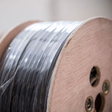 Close-up of the AVSL Mercury 100V line speaker cable on a wooden 100m reel, showing black PVC-sheathed cable wound tightly around the spool.