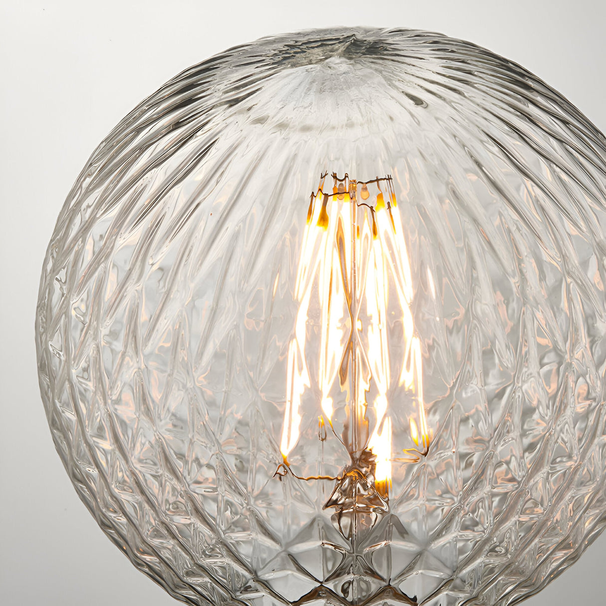 Endon 4W E27 LED filament faceted globe bulb in clear glass with visible warm white filament, shown close-up against a light background.