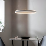 Bramford Pendant in matt nickel and white, a slim ring-shaped LED fixture suspended on thin cables above a marble dining table in a neutral room.
