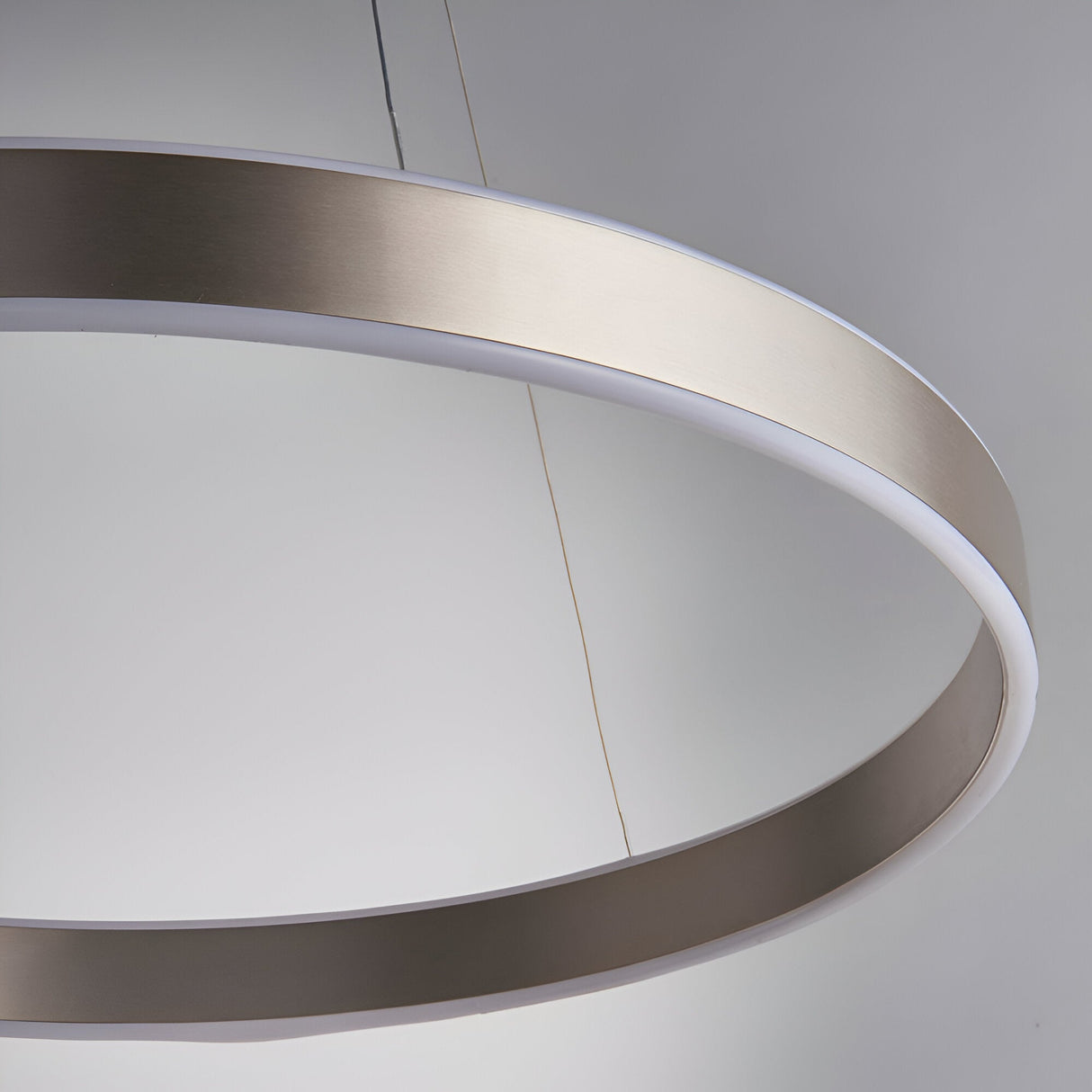 Close-up of the Bramford Pendant ring light in brushed nickel with a white frosted diffuser edge, suspended on a thin cable against a plain grey background.