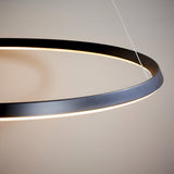Close-up of the Cliffton LED pendant light, a black metal ring with an integrated white diffuser, suspended on wire cables against a neutral background.