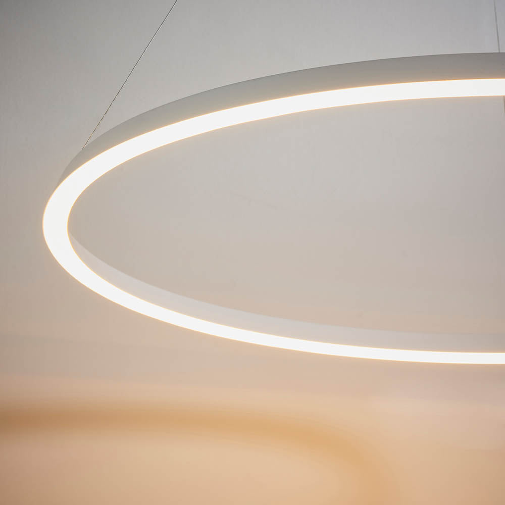 Endon Cliffton LED pendant in white, close-up of the slim illuminated ring with warm-glow diffuser, suspended by fine wires against a neutral wall.