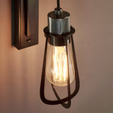 Endon Camden industrial wall light with black cage shade, exposed E27 filament bulb, and chrome knurled detail on a stepped bracket.