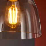 Camden Pendant Light in Chrome, Black & Grey, close-up of glass dome shade with visible E27 filament bulb and brass rim trim.