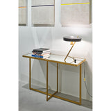 Tablo Bronze Mirrored Glass Console Table with X-shaped metal legs, styled with stacked books beneath a desk lamp in a room with framed wall art.