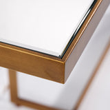 Close-up of the Tablo console table's corner, showing the bronze metal frame edging the mirrored glass top against a plain white background.