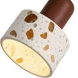 Close-up of the Terroso 1 Light Drum Travertine Single Pendant, featuring a light beige, speckled shade glowing warmly and attached to a smooth walnut brown base.