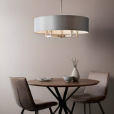 Endon Bramstead 5 light pendant with grey fabric drum shade and matt nickel frame above a round wooden dining table with two chairs.