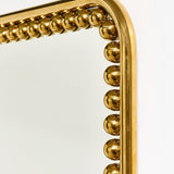 Close-up corner detail of the Diva Square 95cm wall mirror, showing a gold beaded frame of individual spheres around a plain glass mirror against a white background.