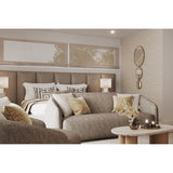 Opera Three Circle Gold Rimmed Wall Mirror, 119cm, three joined circular mirrors decreasing in size with gold rims, shown mounted on a textured wall beside a bed and sofa.