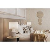 Opera Three Circle Gold Rimmed Wall Mirror 119cm mounted above a bedside table in a bedroom, three joined gold-rimmed circular mirrors decreasing in size top to bottom.