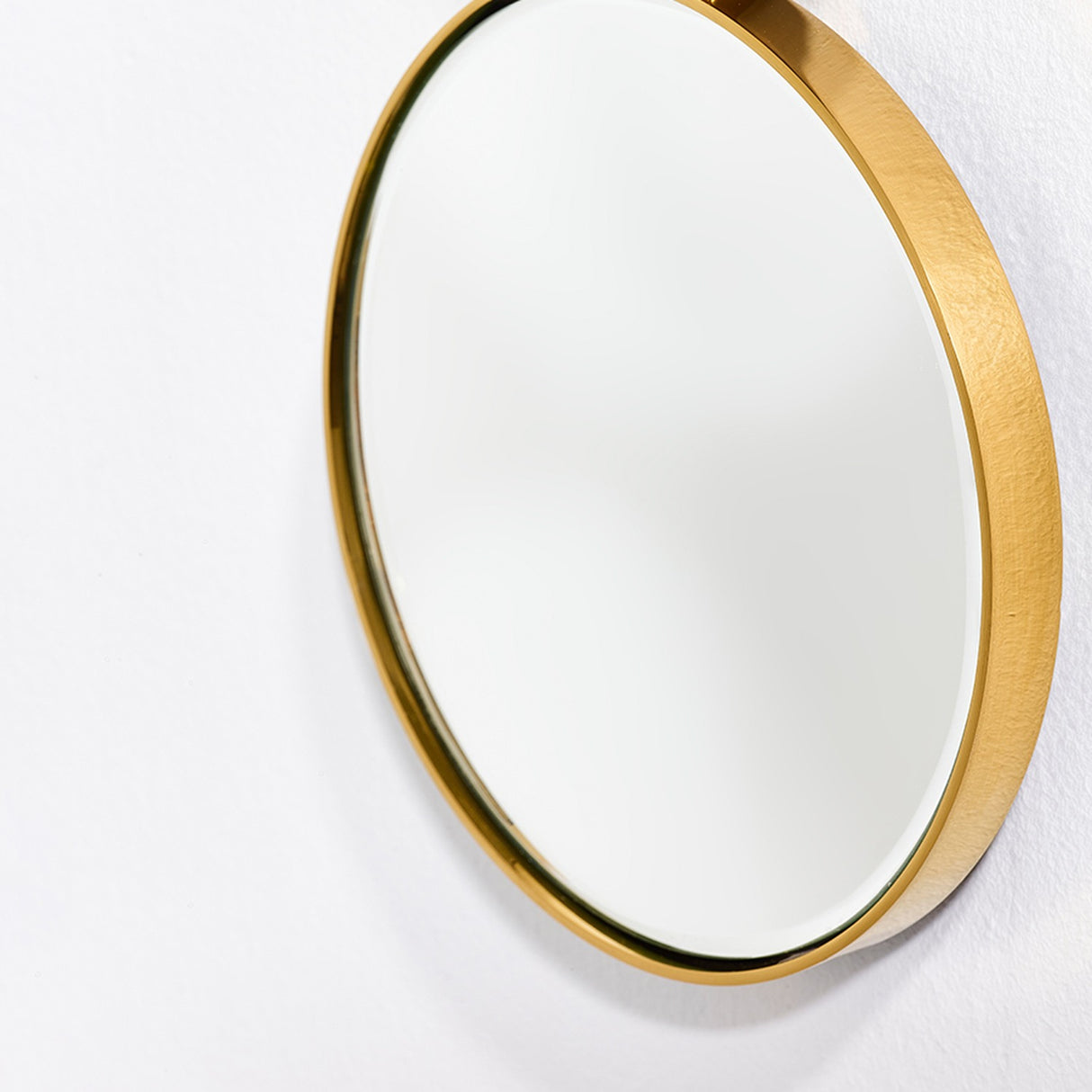 Close-up of the Opera Three Circle Gold Rimmed Wall Mirror 119cm, showing the bevelled glass edge and brushed gold frame against a plain white wall.