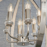 Cliffbury 6 Light Pendant in polished nickel, close-up of candle-style bulbs on curved arms with faceted crystal details against a mirrored frame.