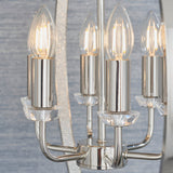 Close-up of the Cliffbury 6 Light Pendant in nickel, showing lit bulbs on cylindrical holders with faceted crystal accents and curved metal arms.