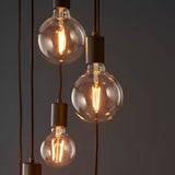 Marlowe 6 Light Pendant in matt black, showing globe bulbs on staggered black fabric flex drops against a dark background.