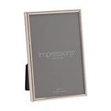 Thin oblong photo frame in silver-plated metal with slim rounded edge, holding a 4x6in print, shown upright on a plain white background.
