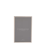 Thin oblong silverplated metal photo frame with slim rounded edge, holding a 4x6in print, shown upright on a plain white background.