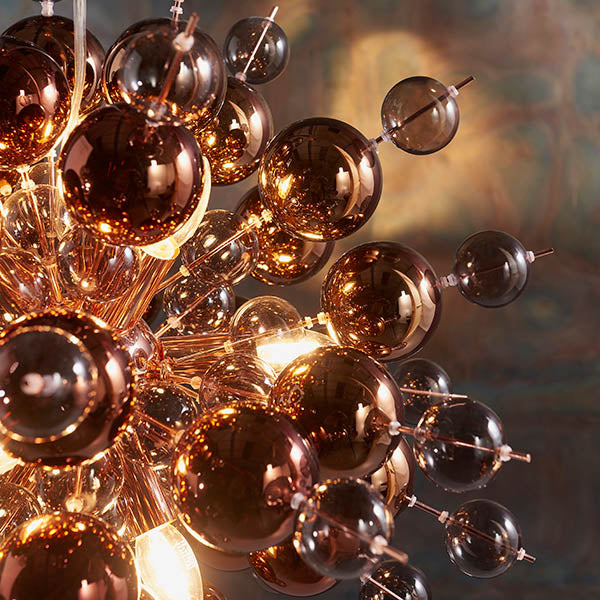 Endon Brockford 9 Light Cluster Pendant in copper, close-up of smoked mirror and tinted glass spheres on plated metalwork with warm glowing lamps.