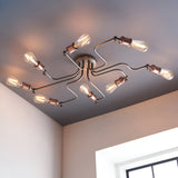 Brackley 8 Light Semi-Flush Ceiling Light in pewter metal finish with copper-toned fittings and exposed bulbs, shown angled across a bedroom ceiling.