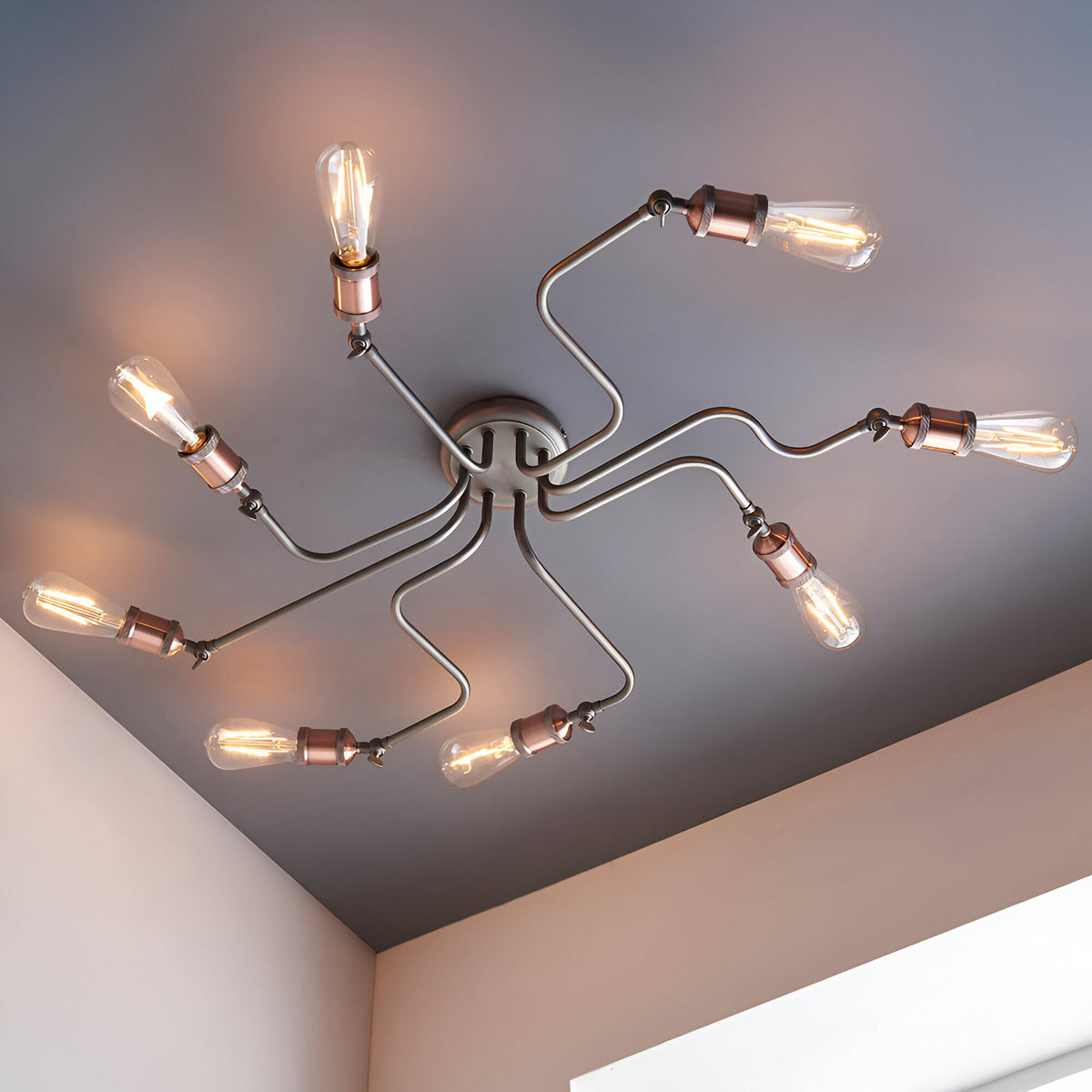 Brackley 8 Light Semi-Flush Ceiling Light in pewter finish with copper-toned fittings, angular metal arms holding exposed E27 bulbs, mounted on a grey ceiling.