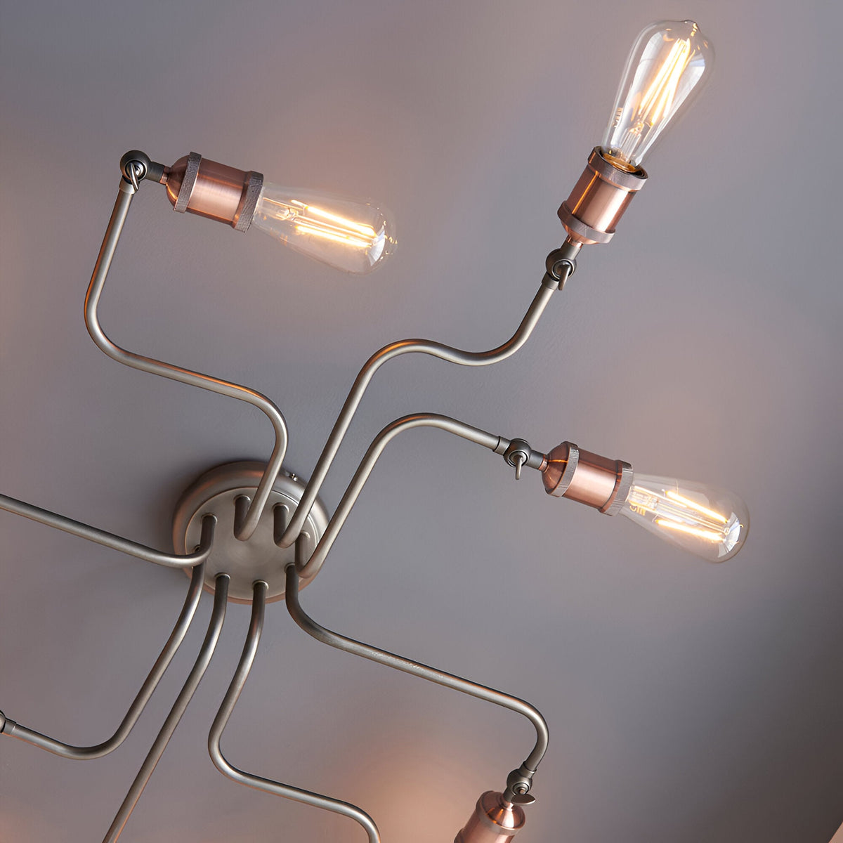 Brackley 8 Light Semi-Flush Ceiling Light in pewter finish, close-up of angled metal arms with copper-tone lamp holders and exposed E27 filament bulbs.