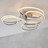 Endon Ravel LED semi-flush ceiling light in chrome, with four interlocking illuminated rings arranged around a circular base plate on a white ceiling.