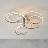 Endon Ravel LED semi-flush ceiling light in chrome, featuring five interlinked illuminated rings in a sculptural cluster against a plain light background.