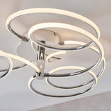 Endon Ravel semi-flush ceiling light in chrome with intertwined illuminated LED rings in a swirling arrangement, shown close-up against a light ceiling.
