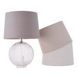 Endon Brockdale table lamp with clear ribbed glass base and satin nickel detailing, shown with grey, taupe and white fabric shade options on a white background.