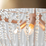 Close-up of the Bevdale 5 Light Pendant in gold, showing tiered strands of clear glass beads and an exposed bulb beneath a metal shade.