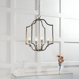 Endon Caldbourne 4 light pendant in antique brass with curved open frame and clear crystal bobeches, hung from a chain above a mirrored console.