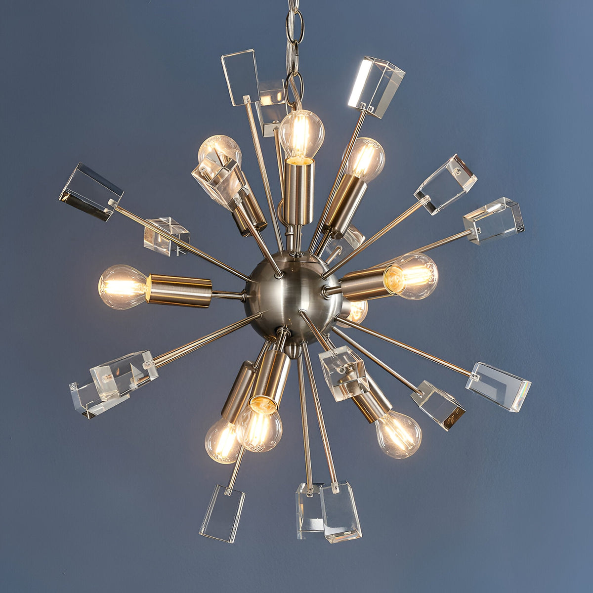 Carlgrove 9-Light Pendant in satin nickel with sputnik-style rods, clear crystal glass accents, and exposed bulbs, shown on a grey background.