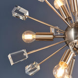 Close-up of the Carlgrove 9-Light Pendant in satin nickel with radiating metal rods, clear crystal glass blocks, and exposed bulbs against a grey background.