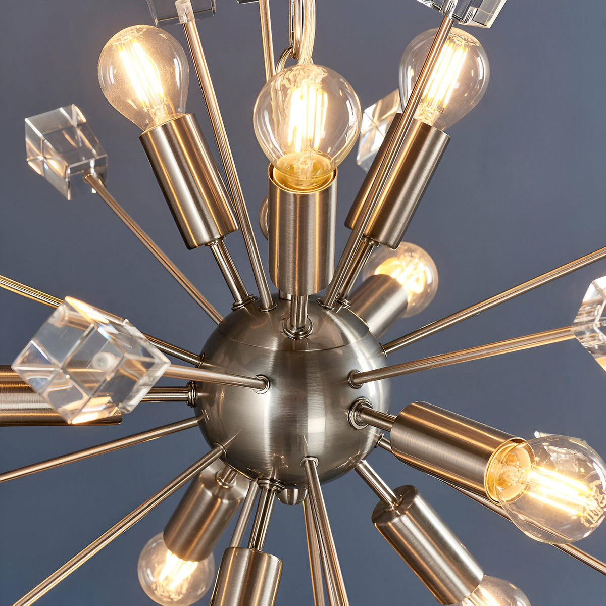 Close-up of the Carlgrove 9 Light Pendant in satin nickel, showing radiating rods with clear crystal glass cubes and exposed bulbs around a central sphere.