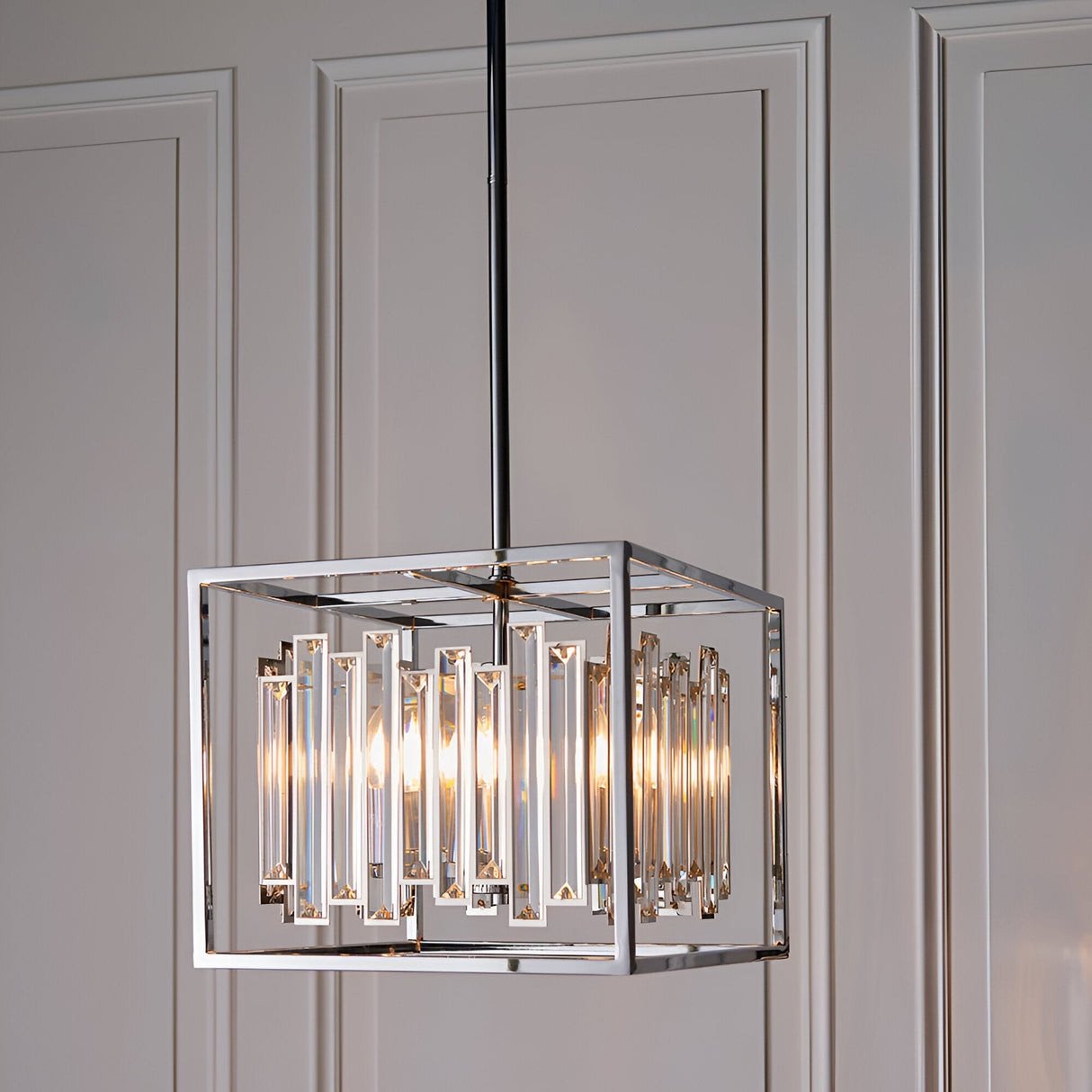 Endon Aldbourne 4 light pendant with square polished chrome frame and bevelled glass crystals, suspended from a rod against panelled walls.