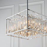Aldbourne 6 Light Pendant in polished chrome with a square frame and bevelled crystal glass rods, shown against a panelled white wall.