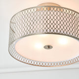Endon Rosaline 3 light flush ceiling light in nickel with perforated circle drum shade and frosted glass diffuser, illuminated against a white ceiling.