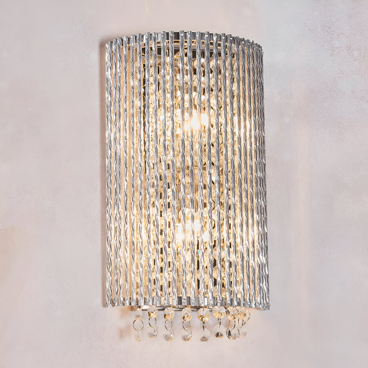 Endon Isadora 2 light wall light with twisted polished chrome rods and K9 clear crystal droplets, illuminated against a plain neutral wall.