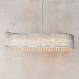 Endon Isadora 8 light linear pendant with a wave-shaped polished chrome frame and clear crystal detailing, suspended against a neutral background.