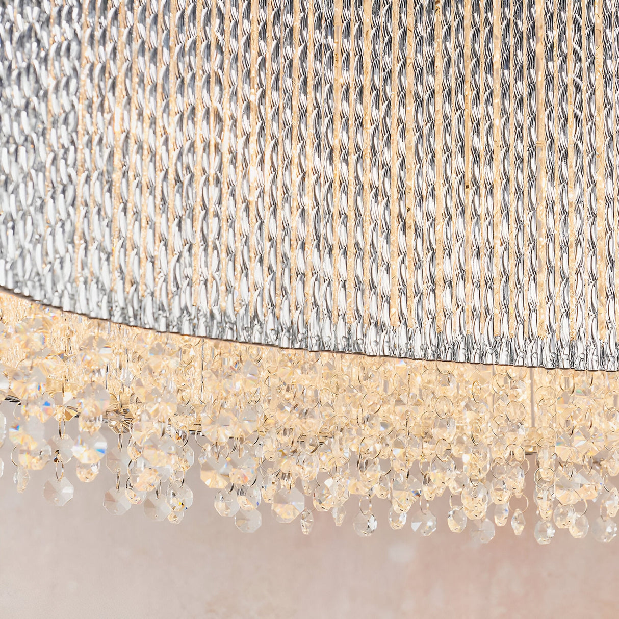 Close-up of Endon Isadora linear pendant showing twisted polished chrome rods and rows of clear K9 crystals catching warm light along the base.
