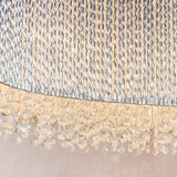Close-up of Endon Isadora linear pendant showing twisted polished chrome rods and rows of clear K9 crystals catching warm light along the base.